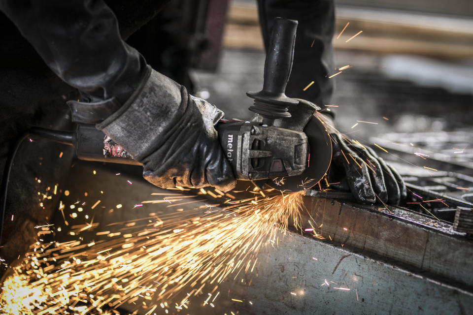 Klitten, Germany: A worker cuts metal in the workshop of a blacksmith 