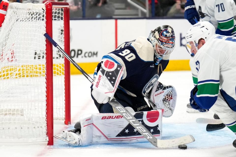 Oct 18, 2022; Columbus, Ohio, USA;  Columbus Blue Jackets goaltender Elvis Merzlikins (90) deflects a shot attempt during the second period between the Columbus Blue Jackets and the Vancouver Canucks at Nationwide Arena. Mandatory Credit: Joseph Scheller-The Columbus Dispatch