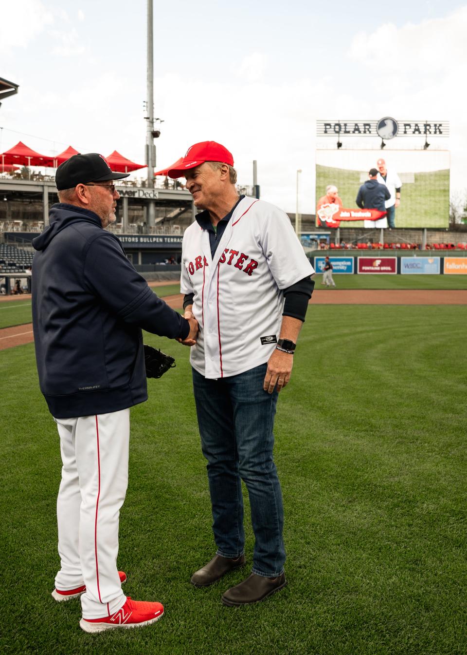 Former Red Sox teammates Rich Gedman (left) and John Trautwein shake hands after the latter threw out the ceremonial first pitch ahead of the WooSox game on Thursday at Polar Park.