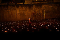 <p>A Yeoman of the Guard is seen amongst lit torches, part of the installation ‘Beyond the Deepening Shadow’ at the Tower of London, in London, Britain, November 7, 2018. (Photo from Reuters/Dylan Martinez) </p>