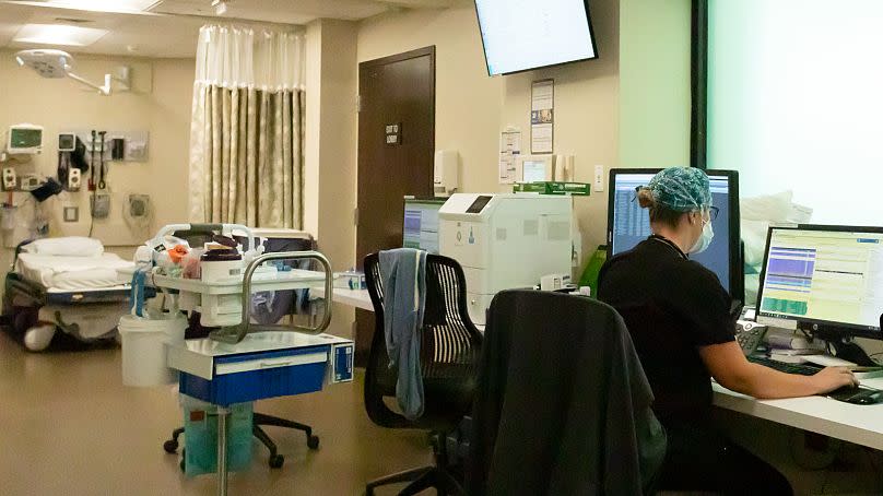 A staff member of the emergency department works at a computer terminal at a hospital in Oregon, 2021.