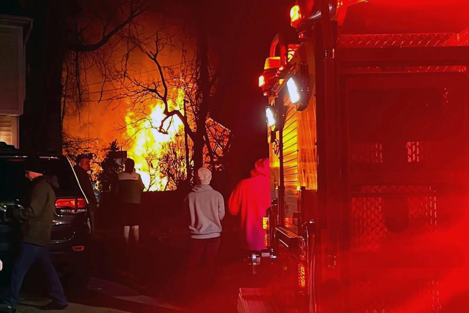 Flames are seen at a distance where a home exploded, Monday night, Dec. 4, 2023, in Arlington, Virginia.