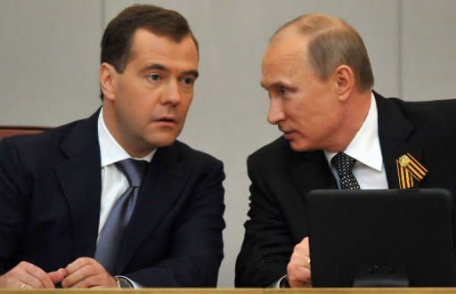 Former Russian President Dmirty Medvdev (L) speaks with Russian President Vladimir Putin (R) during a State Duma conference in Moscow. Russia's new President Vladimir Putin on Tuesday won parliamentary approval for his predecessor Dmitry Medvedev to become prime minister, as protesters tried new tactics to keep up pressure on the Kremlin