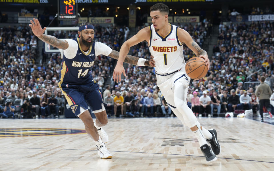 Denver Nuggets forward Michael Porter Jr., right, drives to the basket past New Orleans Pelicans forward Brandon Ingram, left, in the first half of an NBA basketball game on Monday, Nov. 6, 2023, in Denver. (AP Photo/David Zalubowski)
