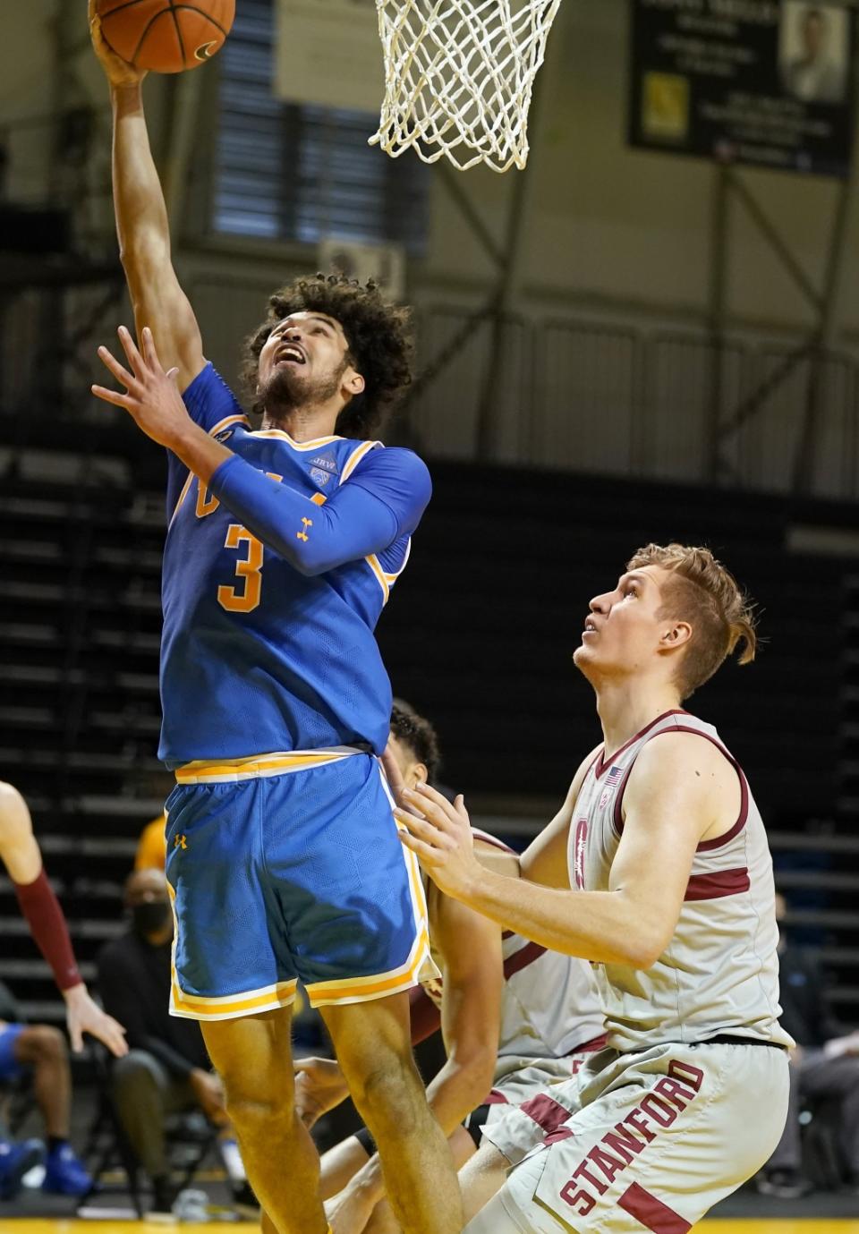 UCLA's Johnny Juzang drives to the basket against Stanford's Lukas Kisunas during the second half Jan. 23, 2021.