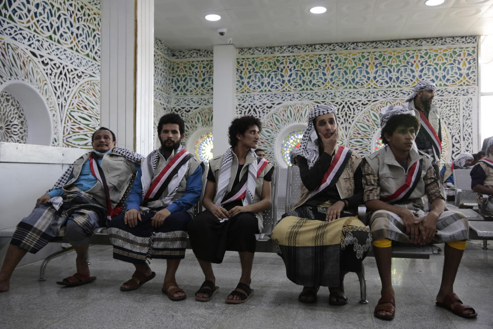 Houthi prisoners sit after they landed at Sanaa airport, Friday, April 14, 2023. An exchange of more than 800 prisoners linked to Yemen's long-running war them began Friday, the International Committee for the Red Cross said. The three-day operations will see flights transport prisoners between Saudi Arabia and Yemen's capital, Sanaa, long held by the Iranian-backed Houthi rebels. ((AP Photo/Hani Mohammed)