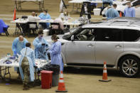 Workers administer COVID-19 tests at a drive-through facility set up in the Williamson County Agricultural Center, Thursday, July 2, 2020, in Franklin, Tenn. Tennessee Gov. Bill Lee issued a stern warning to the public Wednesday as Tennessee registered its highest daily increase in positive COVID-19 tests for the third time in a week and a half. (AP Photo/Mark Humphrey)