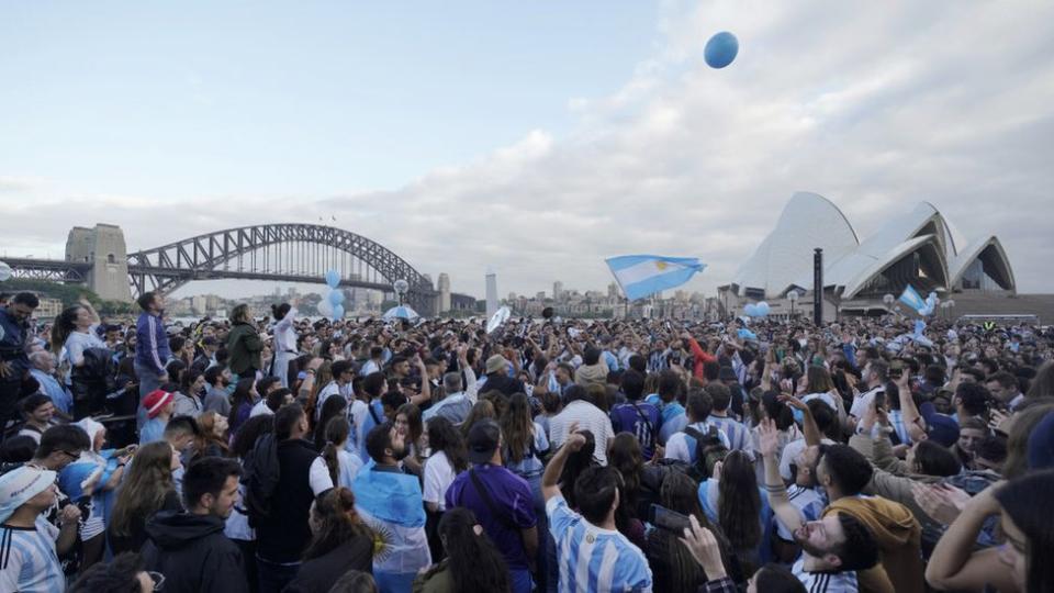 Gente junto al Harbour Bridge de Sidney con camisetas albicelestes.