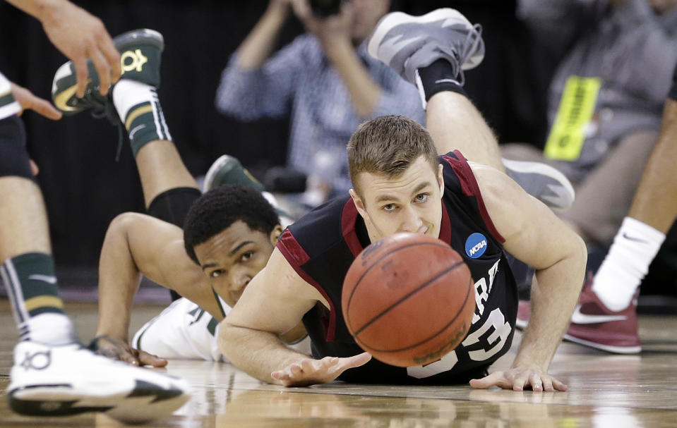 Harvard's Evan Cummins, right, and Michigan State's Alvin Ellis III eye a loose ball in the first half during the third round of the NCAA men's college basketball tournament in Spokane, Wash., Saturday, March 22, 2014. (AP Photo/Elaine Thompson)