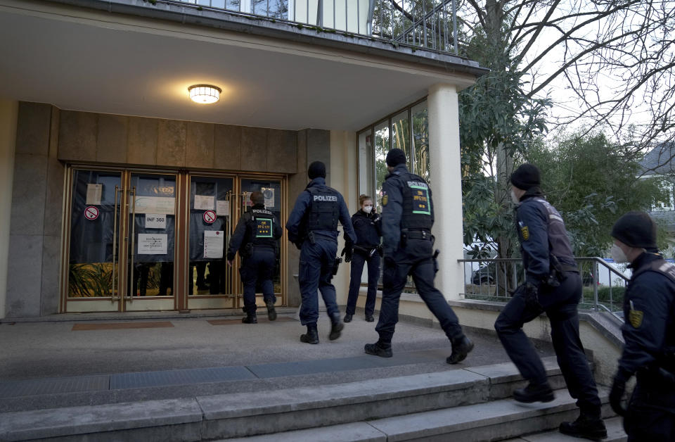 Police officers enter the crime scene on the grounds of the Heidelberg University in Heidelberg, Germany, Monday, Jan. 24, 2022. German police say a lone gunman wounded several people at a lecture theatre in the southwest city of Heidelberg on Monday. Police said in a brief statement that the perpetrator was dead but didn't give details of how that happened. (AP Photo/Michael Probst)