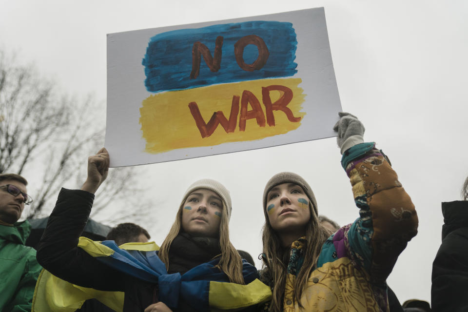 Two young women protesting the Russian invasion of Ukraine hold up a sign reading: No war.