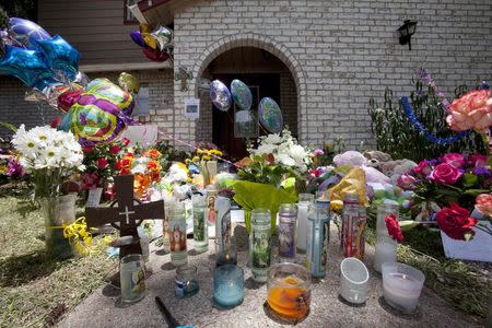 Ribbons, candles, cards, flowers and stuffed animals are among the items wellwishers are leaving at the house where six members of the Stay family were murdered on Wednesday in Spring, Texas July 12, 2014. REUTERS/Daniel Kramer