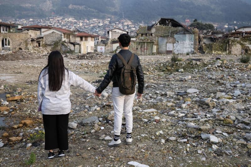 Siblings Arzu (L) and Mehmet stand in the rubble of Antakya's old town. As Turkey marks the first anniversary of the 7.8-magnitude quake that struck last year. Boris Roessler/dpa