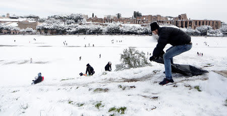 A man prepares to slide with a plastic bag during a heavy snowfall, at the Circus Maximus, in Rome, Italy February 26, 2018. REUTERS/Yara Nardi