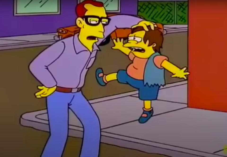 Nelson Muntz  picked up by a man in glasses on a sidewalk scene from "The Simpsons."