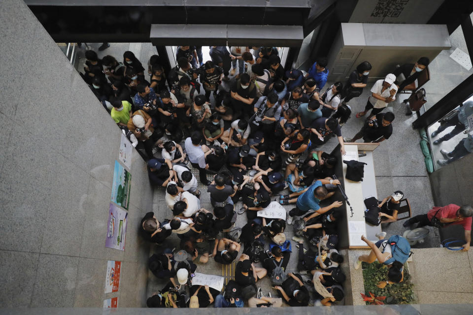 Protesters sit down to block the entrance to the Hong Kong Revenue Tower in Hong Kong on Monday, June 24, 2019. Hong Kong has been rocked by major protests for the past two weeks over legislative proposals that many view as eroding the territory's judicial independence and, more broadly, as a sign of Chinese government efforts to chip away at the city's freedoms. (AP Photo/Kin Cheung)