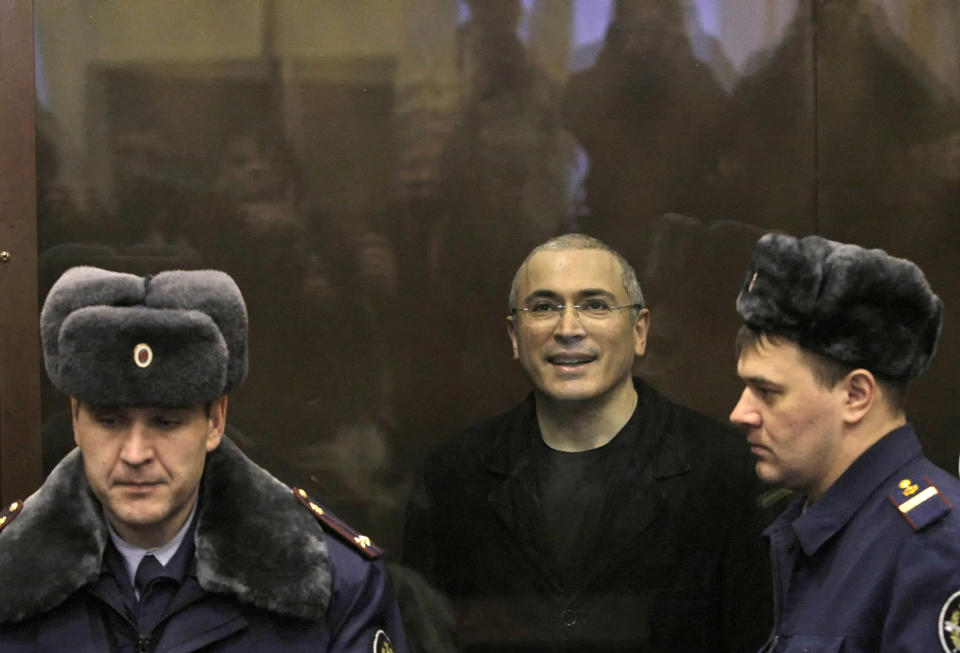 FILE - Mikhail Khodorkovsky, center, is seen behind a glass enclosure at a court room in Moscow, Russia, Thursday, Dec. 30, 2010. Most Russian opposition figures are either in prison at home or are in exile abroad. But they vow that they will still put up a fight against President Vladimir Putin as he seeks yet another term in office in an election scheduled for March. (AP Photo, File)