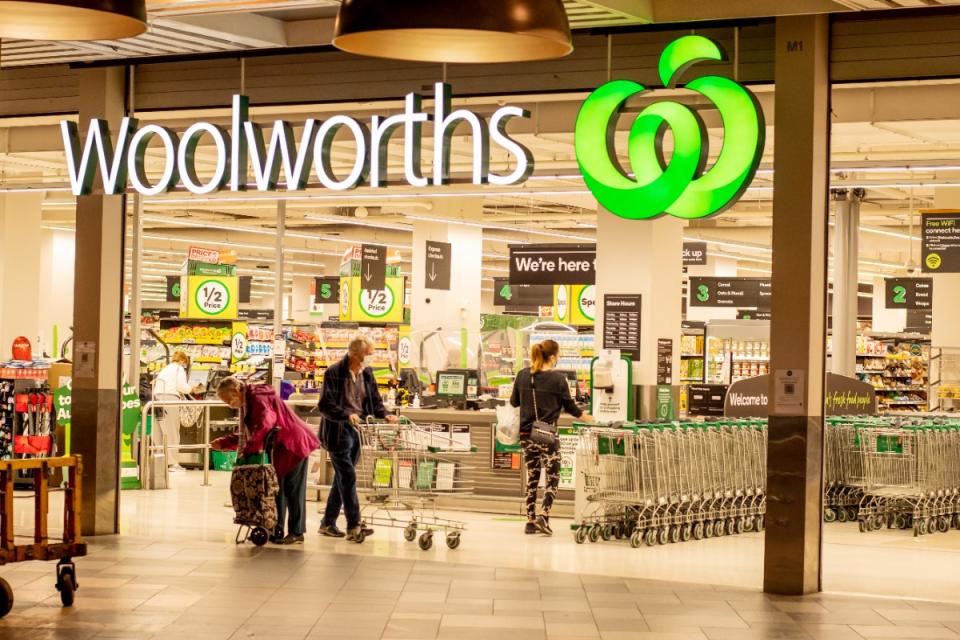 Shoppers at Woolworths storefront.