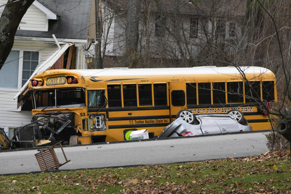 A school bus involved in an accident is seen in New Hempstead, N.Y., Thursday, Dec. 1, 2022. Multiple injuries were reported Thursday when a school bus crashed into a house and another vehicle in a suburb north of New York City. (AP Photo/Seth Wenig)