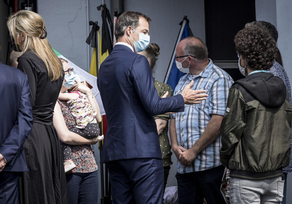 Belgium's Prime Minister Alexander De Croo, center, speaks with residents affected by the recent flooding in Verviers, Belgium, Tuesday, July 20, 2021. Belgium is holding a day of mourning on Tuesday to show respect to the victims of the devastating flooding last week, when massive rains turned streets in eastern Europe into deadly torrents of water, mud and flotsam. (AP Photo/Valentin Bianchi)