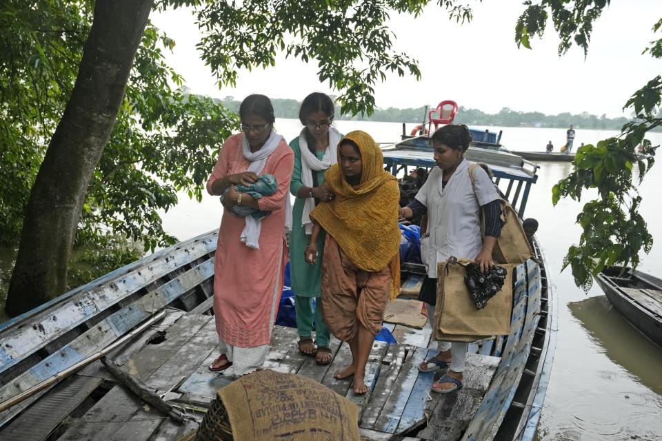 25-year-old Jahanara Khatoon leaves a boat with her newborn baby, on their way to a health centre, in Morigaon district, in the northeastern Indian state of Assam, Wednesday, July 3, 2024. (AP Photo/Anupam Nath)