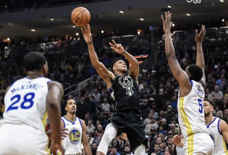 Dec 7, 2018; Milwaukee, WI, USA; Milwaukee Bucks forward Giannis Antetokounmpo (34) drives for the basket against Golden State Warriors forward Kevon Looney (5) in the second quarter at the Fiserv Forum. Benny Sieu-USA TODAY Sports