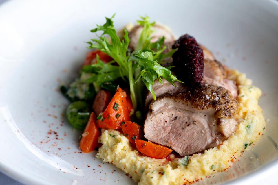 The seared duck breast with grits, wild mushrooms, fava beans, baby carrots, spring onion, dried cherry compote and sauce poivrade, at Le Bar a Boeuf, in Walnut Hills.