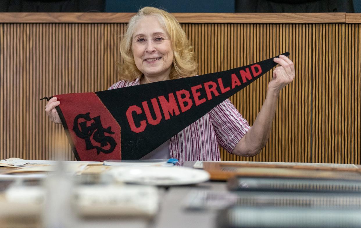 Joni Curtis, a historian on all things Cumberland, with a banner from a long-defunct Cumberland High School, Wednesday, March 1, 2023, in the Cumberland neighborhood of Indianapolis, which hugs the Hancock County line. 