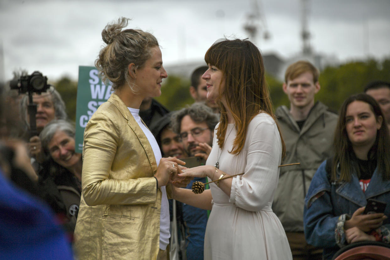 Two women celebrate their marriage on Westminster Bridge, during an Extinction Rebellion protest in London, Monday, Oct. 7, 2019. London Police say some 135 climate activists have been arrested as the Extinction Rebellion group attempts to draw attention to global warming. Demonstrators playing steel drums marched through central London on Monday as they kicked off two weeks of activities designed to disrupt the city. (AP Photo/Alberto Pezzali)