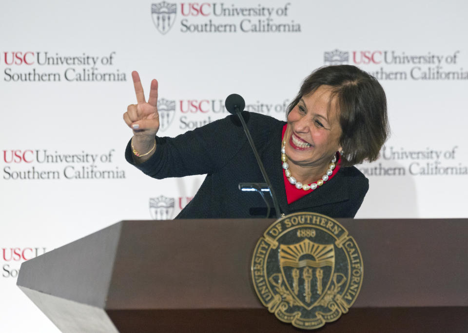 Carol Folt signs the "Trojan salute" after being named as University of Southern California's 12th president in Los Angeles Wednesday, March 20, 2019. The announcement comes a week after news broke of a massive college bribery scandal involving USC and other universities across the country. She will take office as USC's new president on July 1. (AP Photo/Damian Dovarganes)