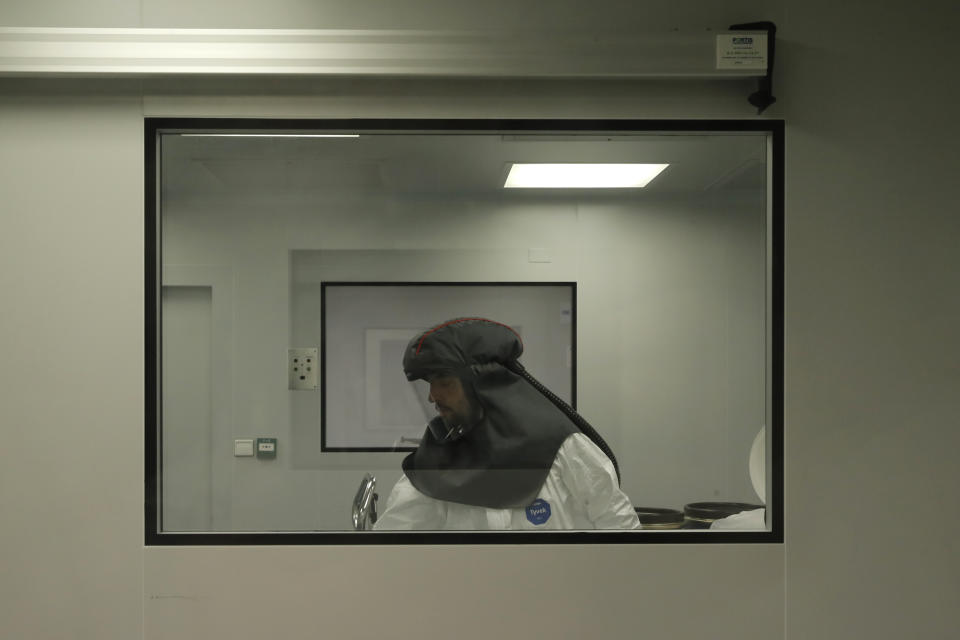 An employee works at the Delpharm plant in Saint-Remy-sur-Avre, west of Paris, Friday, April 9, 2021 in Paris. The Delpharm plant started bottling Pfizer vaccines this week as France tries to make its mark on global vaccine production, and speed up vaccinations of French people amid a new virus surge. (AP Photo/Christophe Ena, Pool)