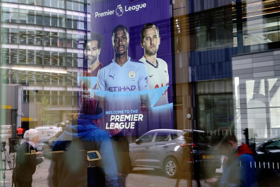 Members of the media are reflected in the glass at the headquarters of the English Premier League in London on March 13, 2020. - The English Premier League suspended all fixtures until April 4 on Friday after Arsenal manager Mikel Arteta and Chelsea winger Callum Hudson-Odoi tested positive for coronavirus. (Photo by Isabel Infantes / AFP) (Photo by ISABEL INFANTES/AFP via Getty Images)