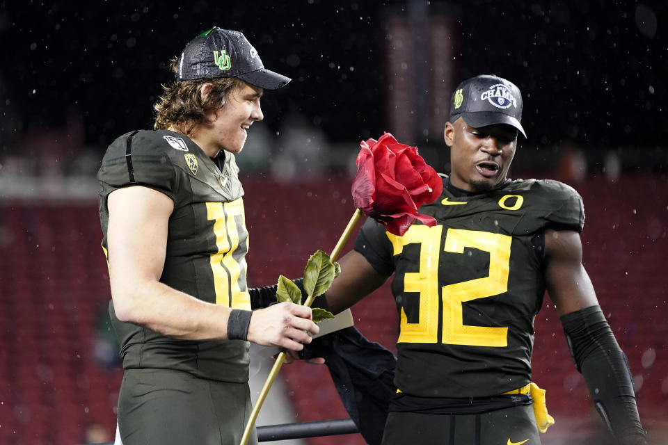 Oregon quarterback Justin Herbert (10) and teammate La'Mar Winston Jr. (32) celebrate after Oregon defeated Utah 37-15 in an NCAA college football game for the Pac-12 Conference championship in Santa Clara, Calif., Friday, Dec. 6, 2018. (AP Photo/Tony Avelar)