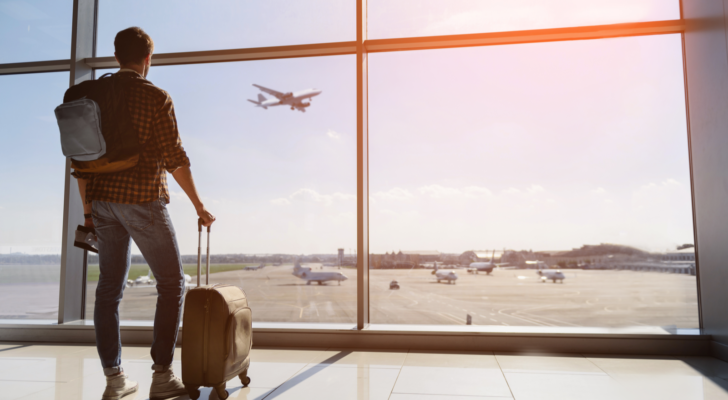 Plane travel. Man standing in airport waiting for flight.