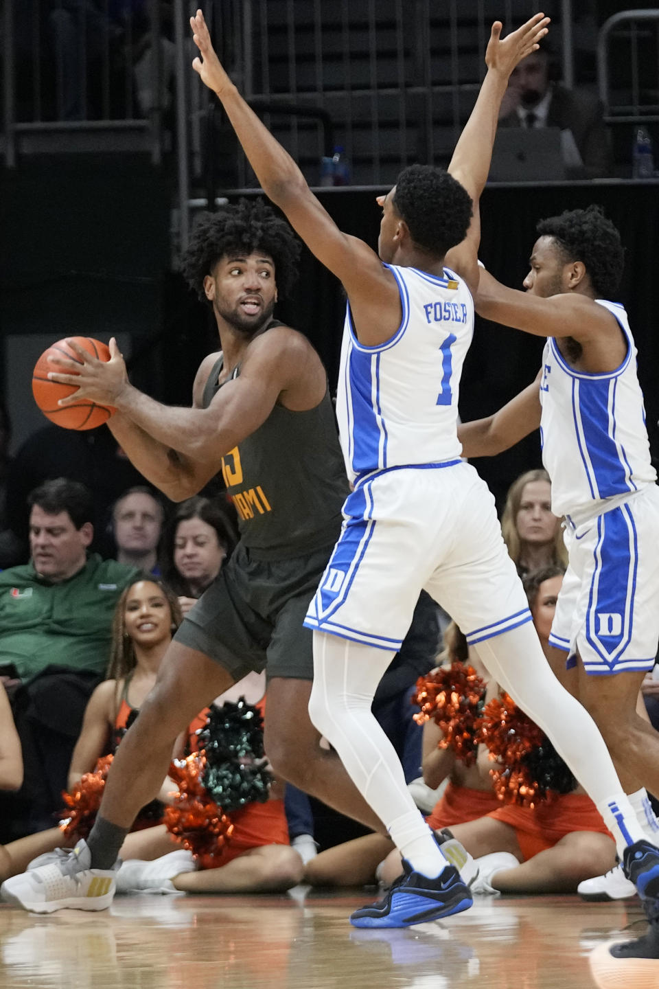 Miami forward Norchad Omier, left, looks for an opening past Duke guards Caleb Foster (1) and Jeremy Roach, right, during the first half of an NCAA college basketball game, Wednesday, Feb. 21, 2024, in Coral Gables, Fla. (AP Photo/Wilfredo Lee)