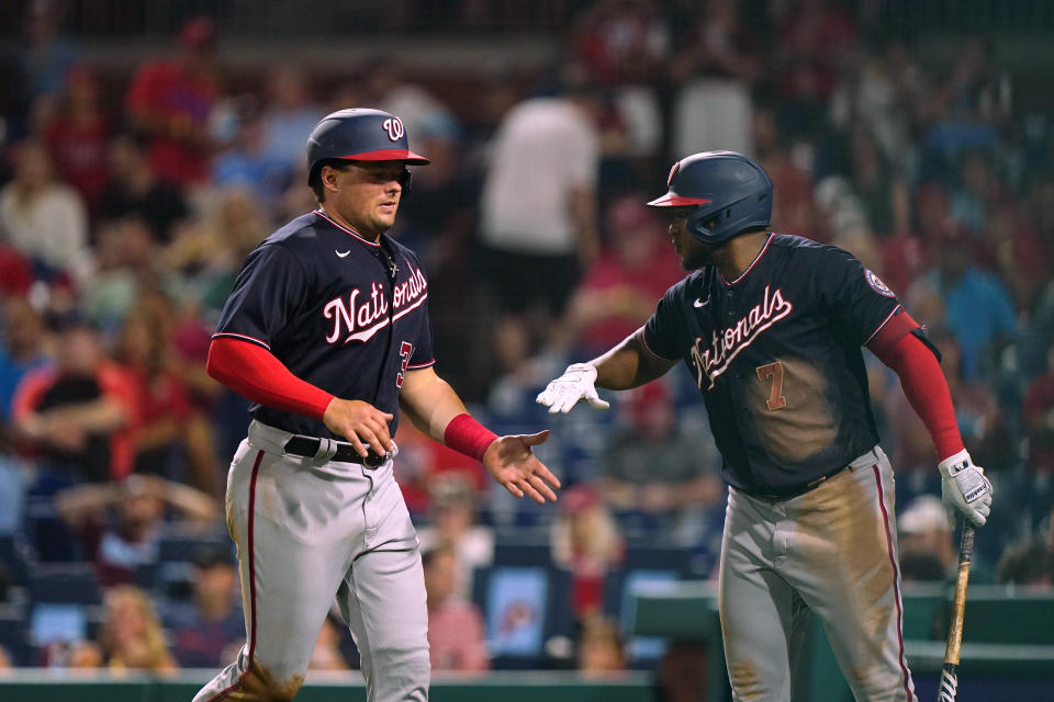 Washington Nationals' Luke Voit, left, celebrates with Darnell Coles after scoring on a wild pitch by Philadelphia Phillies' Noah Syndergaard during the fifth inning of a baseball game Thursday, Aug. 4, 2022, in Philadelphia. (AP Photo/Matt Rourke)