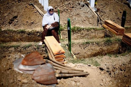 Bosnian Muslim woman sits near a grave before mass funeral in Memorial Center in Potocari near Srebrenica, Bosnia and Herzegovina July 11, 2016. REUTERS/Dado Ruvic