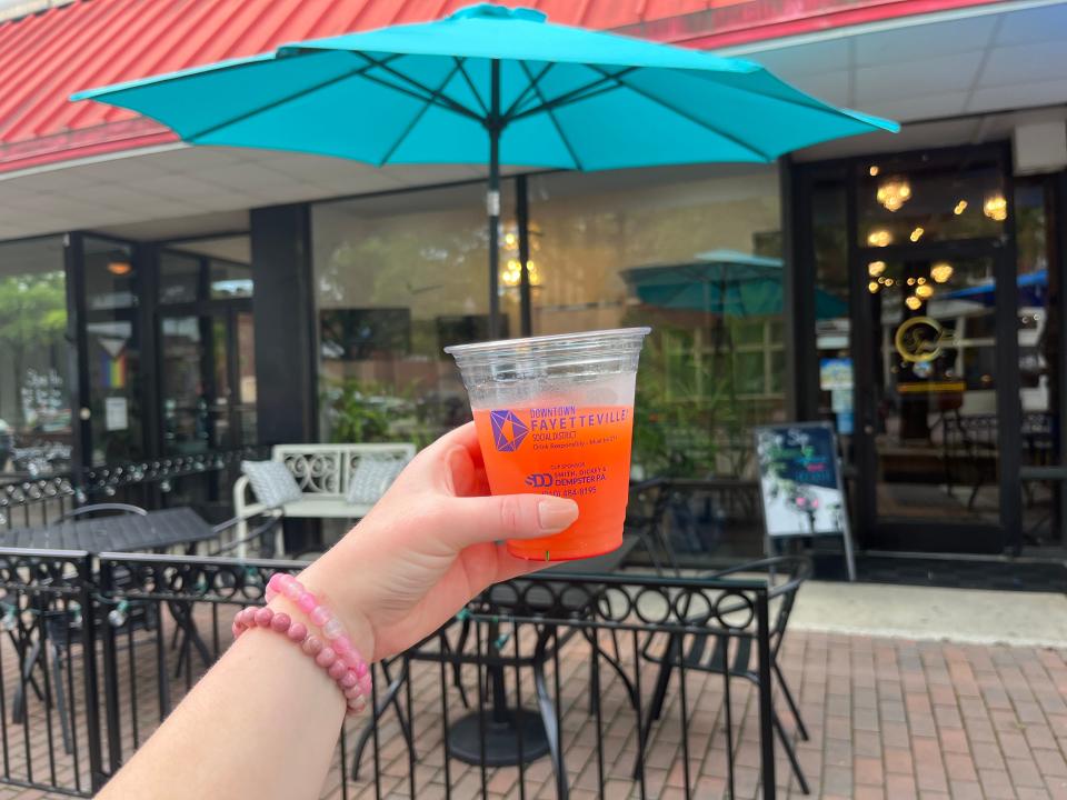 A passionfruit mimosa to go from The Sip Room, 106 Hay St. in Fayetteville. On Dec. 11, the city voted to make the trial Downtown Social District permanent.