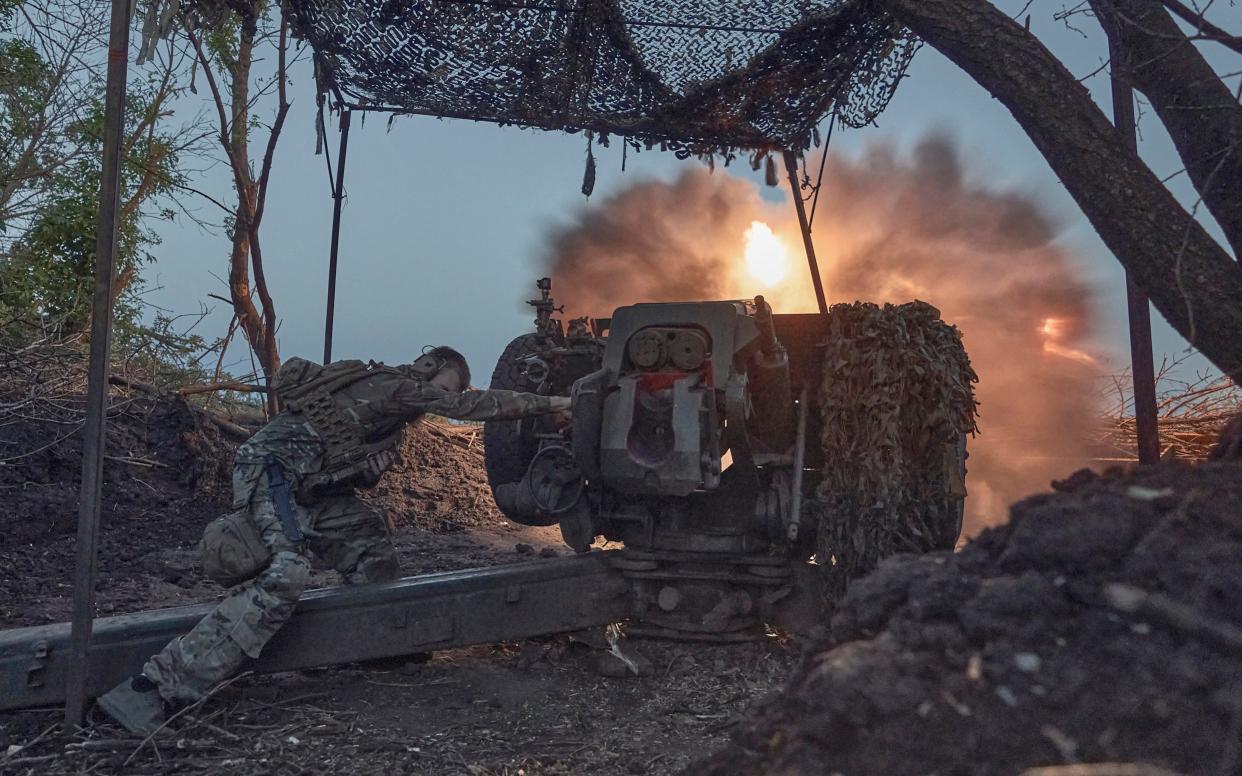A Ukrainian serviceman fires a cannon near Bakhmut
