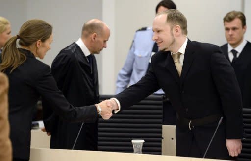 Rightwing extremist Anders Behring Breivik, who killed 77 people in twin attacks in Norway last year, greets pshyciatrist Synne Soerheim (L) in Oslo district courtroom at the start of his trial