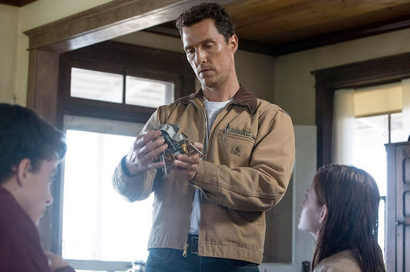 Actor Matthew McConaughey holds a model of the Apollo lunar module in a scene from Christopher Nolan's "Interstellar."