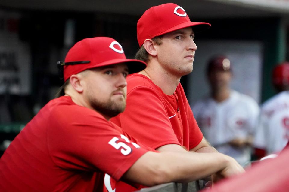 Cincinnati Reds starting pitcher Graham Ashcraft (51), left, and Cincinnati Reds starting pitcher Nick Lodolo (40) watch from the dugout during the fifth inning of a baseball game against the Atlanta Braves, Friday, July 1, 2022, at Great American Ball Park in Cincinnati. The Atlanta Braves won, 9-1. 