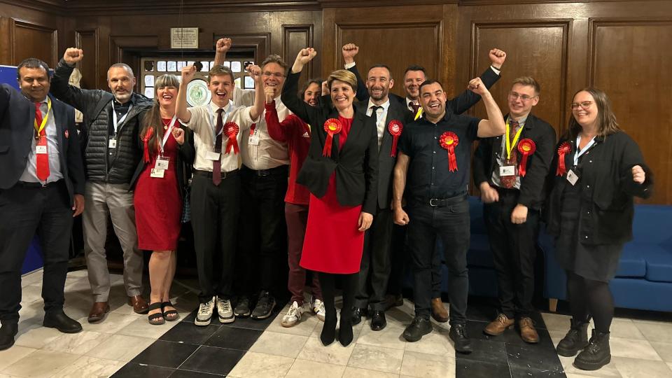 MP Emma Hardy and canvassers wearing Labour Party rosettes cheer and smile for a photograph.