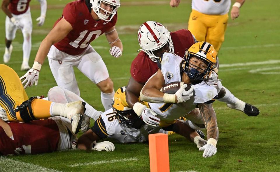 California Golden Bears running back Jaydn Ott (1) extends with the ball toward the goal line during a game against Stanford Cardinal at Stanford Stadium in November 2023.