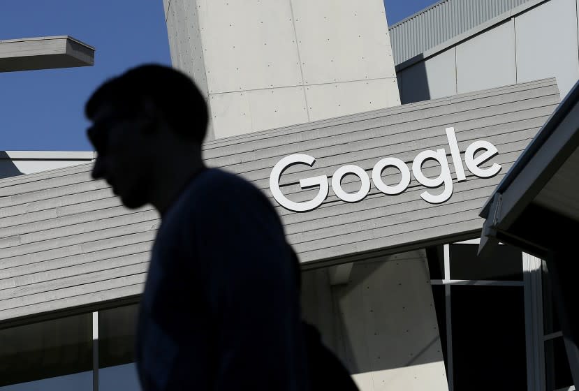 FILE - In this Nov. 12, 2015, file photo, a man walks past a building on the Google campus in Mountain View, Calif. Google said state-based hackers have targeted the campaigns of both President Donald Trump and former Vice President Joe Biden, although it saw no evidence that the phishing attempts were successful. The company confirmed the findings after the director of its Threat Analysis Group, Shane Huntley, disclosed the attempts Thursday, June 4, 2020, on Twitter. (AP Photo/Jeff Chiu, File)