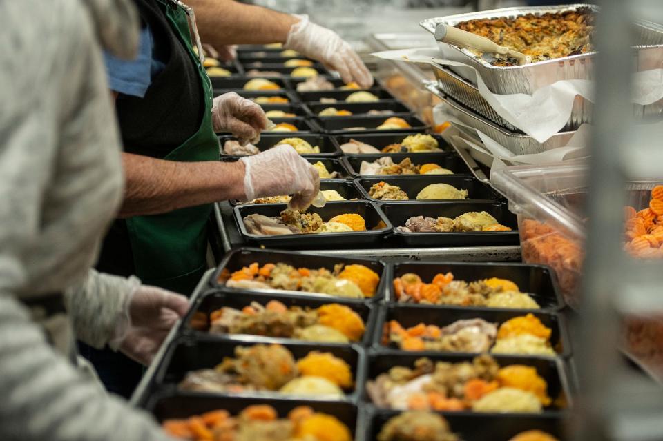An assembly line prepares hundreds of Thanksgiving dinners for distribution at Open Table in Maynard, Nov. 13, 2023.