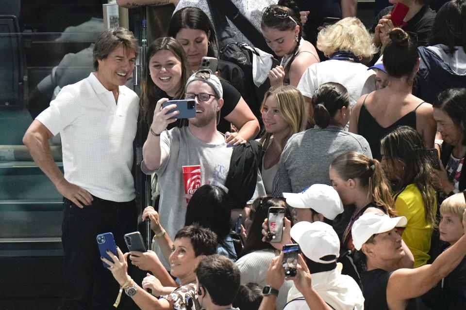 El actor Tom Cruise, izquierda, interactúa con los fans mientras asiste a la ronda de clasificación de gimnasia artística femenina en los Juegos Olímpicos de Verano de 2024, el domingo 28 de julio de 2024, en París, Francia. (Foto AP/Francisco Seco)