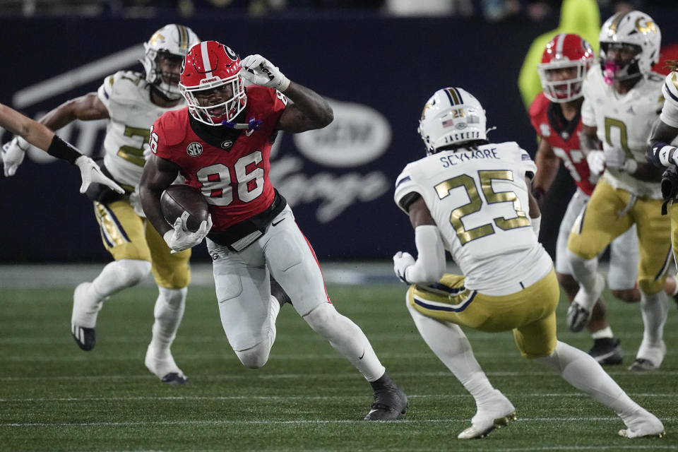 Georgia wide receiver Dillon Bell (86) tries to get past Georgia Tech's Taye Seymore (25) as hde returns a kickoff during the second half of an NCAA college football game, Saturday, Nov. 25, 2023, in Atlanta. (AP Photo/John Bazemore)