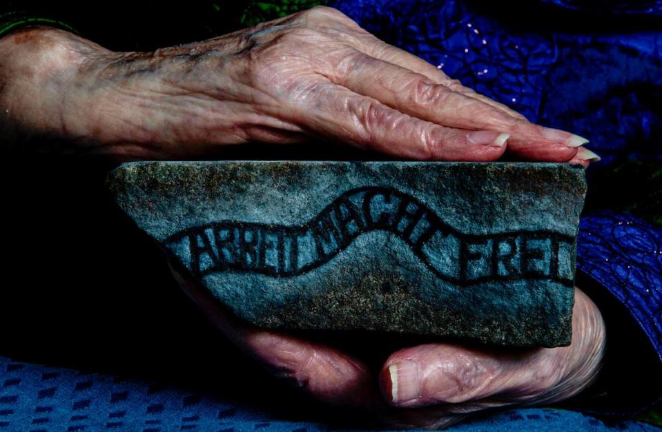 Elizabeth Nussbaum returned to Auschwitz-Birkenau 18 years ago and brought back a stone from the train tracks there. She hired an artist to paint a rendering of the camp on it, along with the slogan above an entrance: “Arbeit Macht Frie,” loosely translated as “Work sets you free.”