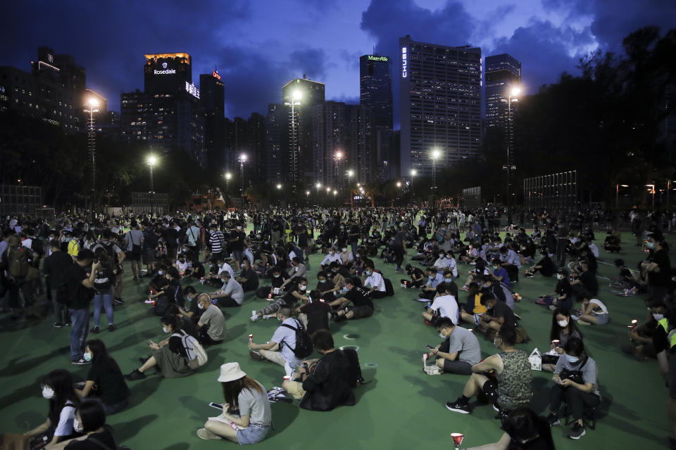 Participants hold candles as they gather for a vigil to remember the victims of the 1989 Tiananmen Square Massacre, despite permission for it being officially denied, at Victoria Park in Causeway Bay, Hong Kong, Thursday, June 4,2020. China is tightening controls over dissidents while pro-democracy activists in Hong Kong and elsewhere try to mark the 31st anniversary of the crushing of the pro-democracy movement in Beijing's Tiananmen Square.(AP Photo/Kin Cheung)